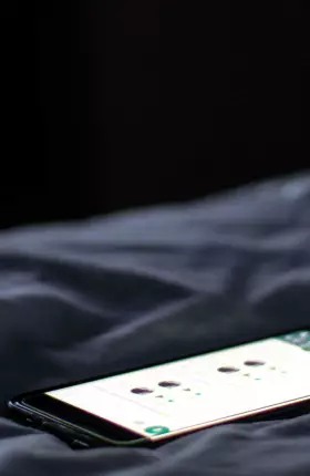 Close-up of a smartphone laying on sheets