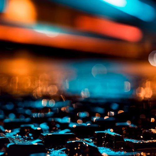 Wet ground illuminated by blue and orange light at night