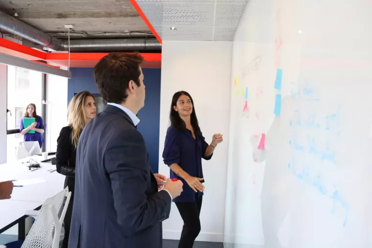 Women and Man in Front of a White Board
