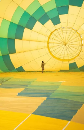 Person standing in a yellow and green parachute-like tent
