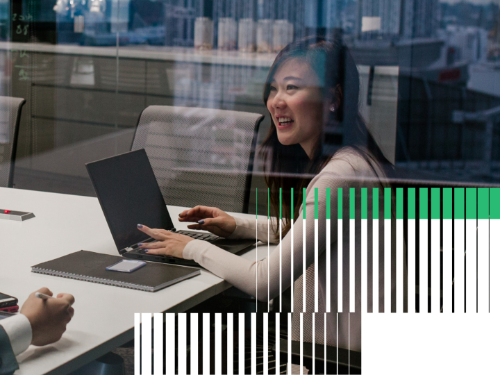 Two People Sitting at a Conference Table Talking with Eachother
