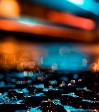 Wet ground illuminated by blue and orange light at night