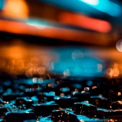 Wet ground illuminated by blue and orange light at night