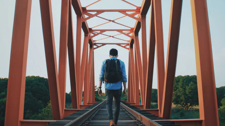 business model innovation matrix Person with backpack walking across an orange metal bridge