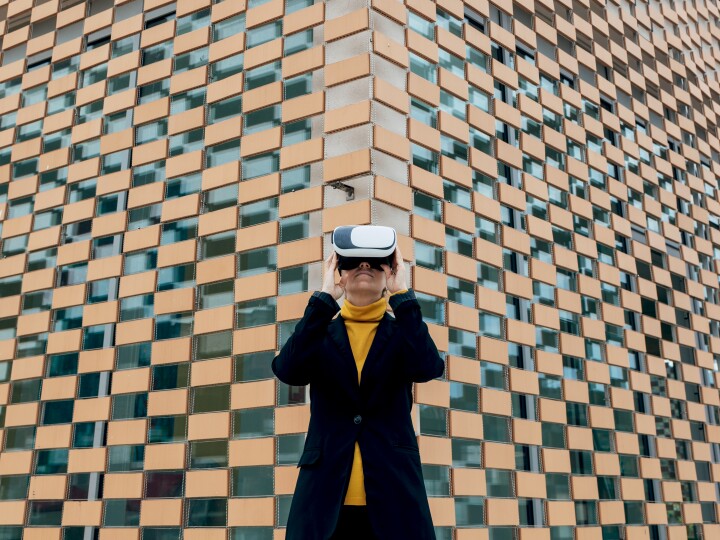LOW ANGLE VIEW OF MAN STANDING AGAINST BUILDING