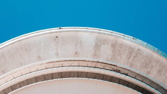 Underside of circular building framed by sky