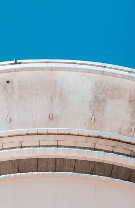 Underside of circular building framed by sky