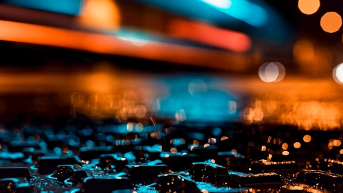 Wet ground illuminated by blue and orange light at night