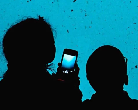 Woman and child with smartphone in hand looking at aquarium