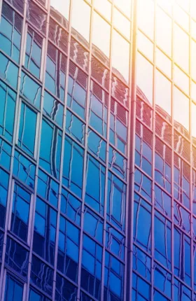 LOW ANGLE VIEW OF GLASS BUILDING AGAINST SKY