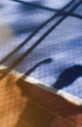 Shadow of person on basketball court flexing arm muscles