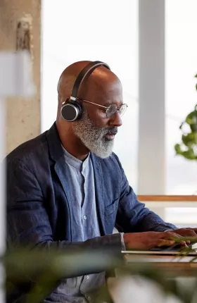 Man working on laptop surrounded by plants