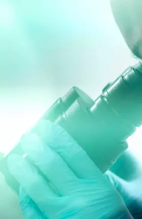 Female scientist looking through microscope