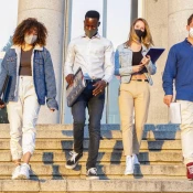 4 students wearing face masks walking down the stairs