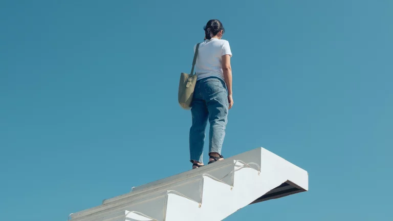 Person standing atop white staircase that goes nowhere