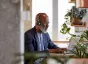 Man working on laptop surrounded by plants