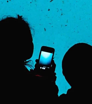 Woman and child with smartphone in hand looking at aquarium