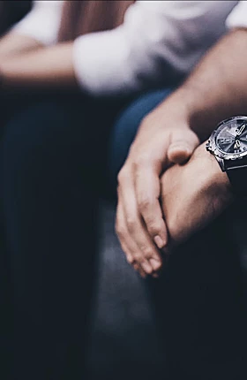 Close up image of two people wearing watches