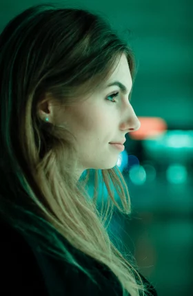 Woman placing hand against blue-green computer screen