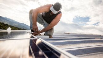 Man adding solar panels to roof