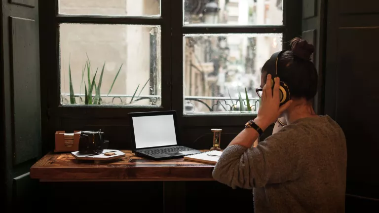 Women with headphones on sitting at desk