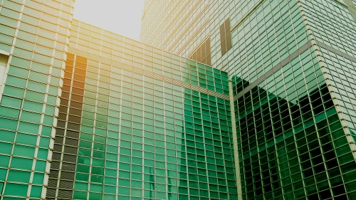 image of glass green building reflecting the sunset