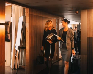 "women walking down corporate office hallway"