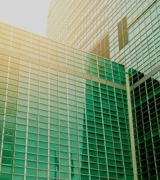 image of glass green building reflecting the sunset