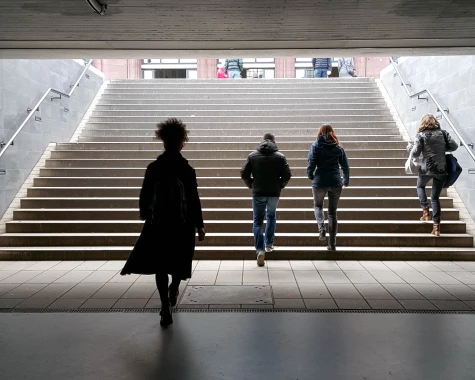Image of People in Coats Walking Up Stairs