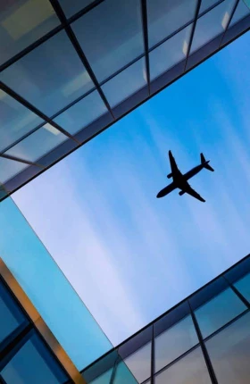 "airplane flying over building"