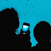 Woman and child with smartphone in hand looking at aquarium