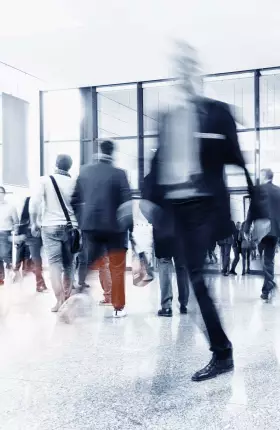 Blurred image of people walking through a building